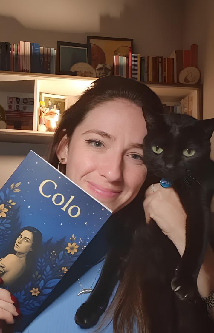 Gabriela Nespini Ubaldini - Autora do livro Colo segurando um exemplar de sua obra com seu gato